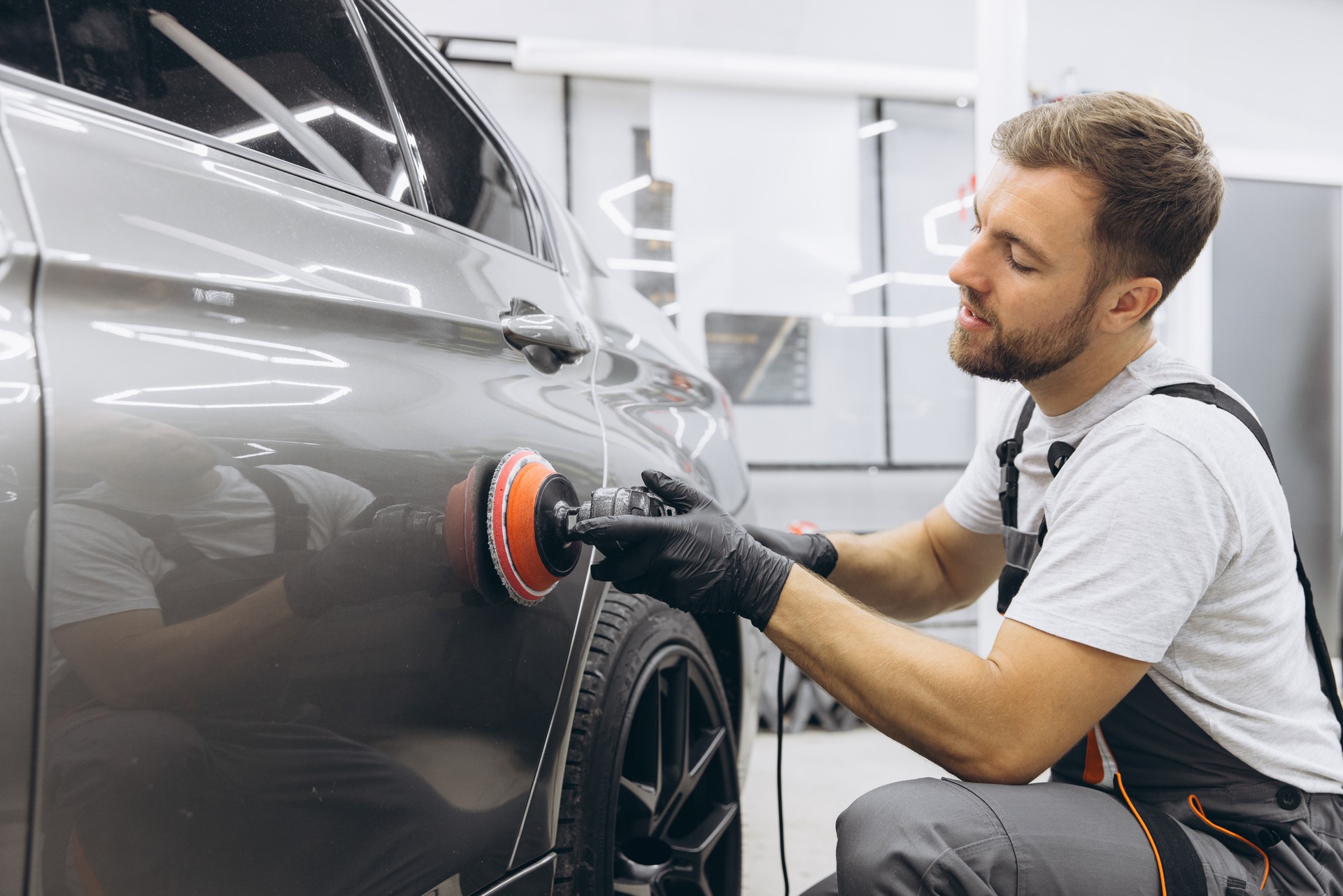 Professional Car Detailing with an Auto Polisher in a Garage Setting